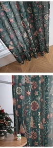 Detail of green Christmas curtains with festive patterns showing fabric texture and soft light