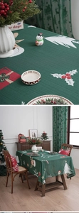 Detail of forest green Christmas tablecloth with white elk and snowflake print patterns