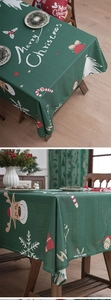 Detailed close-up of dark green Christmas tablecloth with reindeer and snowflake motifs