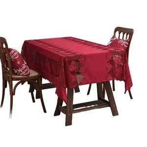 Red lace Christmas tablecloth with Santa and reindeer prints on a long wooden table