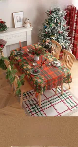 Detailaufnahme der roten Karo-Weihnachtstischdecke mit Stechpalmen und festlichen Motiven