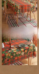 Detailaufnahme der gewellten Kante der rot-grünen Weihnachtstischdecke mit festlichen Motiven