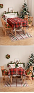 Detail of red and black buffalo plaid Christmas tablecloth with festive floral border