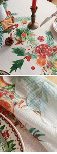 Close-up of Christmas tablecloth featuring festive bells, pine needles, and berries texture