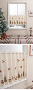 Close-up of Santa Claus and Christmas tree embroidery on cream lace cafe curtain