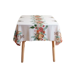 Christmas themed tablecloth with gold bells and festive patterns on scalloped edges