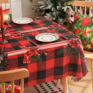 Classic red plaid Christmas tablecloth with pine needles and festive holiday ornaments