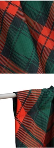 Dettaglio del tessuto scozzese natalizio rosso e verde per set di tende da cucina