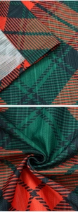 Dettaglio della trama del tessuto scozzese rosso e verde e cuciture della tenda da cucina