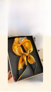 Detailed view of the 70cm silk scarf with floral patterns inside a black luxury gift box
