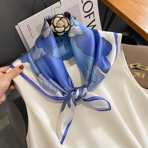 Elegant 65cm silk scarf with blue gradient floral pattern on white blouse