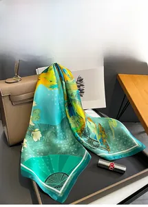 Detailed close-up of lake blue silk square scarf with white magnolia and fan patterns