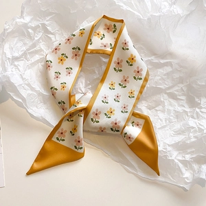 Detail of floral pattern silk scarf with yellow border on textured white paper