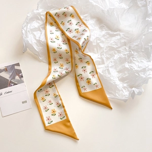 Detailed macro view of the floral print hair scarf with yellow borders on tissue paper