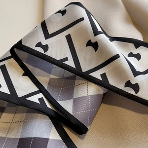 Gros plan d'un foulard en soie à motif géométrique montrant sa texture luxueuse