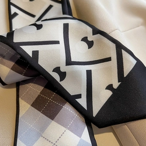 Détail du motif géométrique et de la texture à carreaux d'un foulard gris