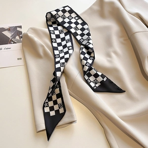 Détail d'un foulard en soie à damier avec graffitis d'étoiles sur vêtement beige