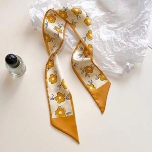 Detail of floral skinny silk scarf with yellow flower print and orange trim on edges