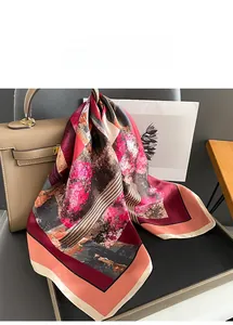 Detail of printed silk scarf with pink and black abstract art hung on a handbag