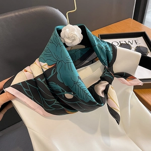 Fashionable silk square scarf with floral print and camellia accessory on white blouse
