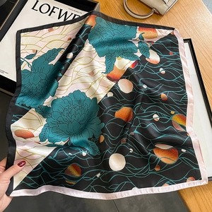 Silk square scarf with dark green peonies and modern wave patterns on wooden desk