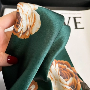 Silk neck scarf with orange rose print on forest green fabric and satin luster finish