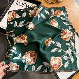 Elegant silk scarf featuring large orange roses on a deep green fabric with pearly sheen