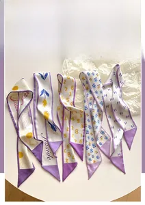Dettaglio di sciarpe twilly in seta con stampe floreali viola e motivi a H