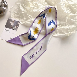 Dettaglio macro di una sciarpa di seta con stampe di tulipani viola e trama morbida
