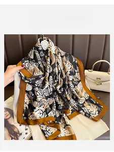 Detailed view of floral and butterfly print silk scarf draped on knitwear background