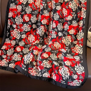 Silk-feel floral scarf with red roses and butterfly print on premium dark leather surface