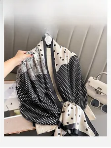 Gros plan sur un foulard en soie à pois noir et blanc avec motifs vintage élégants