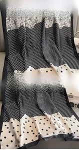 Détail d'un foulard en soie à pois avec des coutures précises et un tissu teint de qualité