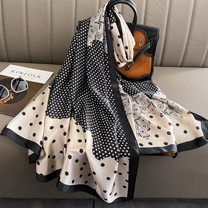 Élégant foulard en soie à pois drapé sur un sac à main aux motifs classiques noir et blanc