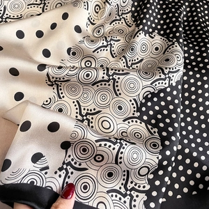 Détail d'un foulard en soie à pois avec texture lisse et bords roulés
