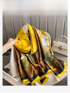 Detail showing elegant silk scarf with yellow and brown lotus patterns and luxury textures