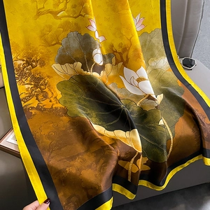Detailed view of silk scarf with lotus landscape pattern and yellow satin texture