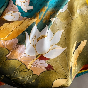 Detailed close-up of smooth silk satin scarf featuring elegant lotus floral prints