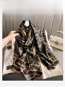 Close-up of elegant black and gold baroque silk scarf with smooth satin texture finish