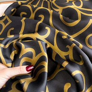 Elegant black and gold silk scarf with baroque floral patterns and soft satin texture