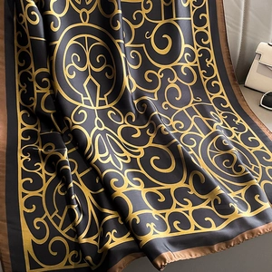 Elegant black and gold silk scarf with baroque floral patterns and smooth satin texture