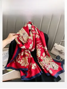 Détail du foulard en soie rouge à motif floral et bordure bleue sur mannequin