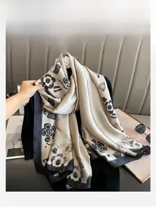 Détail de foulard en soie champagne avec motifs de camélia noir et matelassage