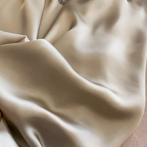 Élégant foulard en soie champagne avec texture lisse et détails de drapé fluides
