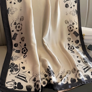 Écharpe élégante en soie champagne avec bordure noire et motifs dessinés sur siège en cuir