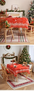 Close-up of red Christmas tablecloth with white reindeer motifs and festive holiday patterns