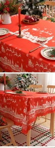 Close-up of red Christmas tablecloth with white deer patterns and wavy scalloped edges