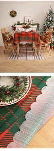Close-up of red and green plaid Christmas tablecloth with woven texture and scalloped edges