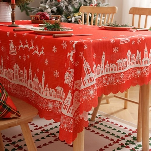 Red Christmas tablecloth with white reindeer and snowflake patterns and scalloped edges