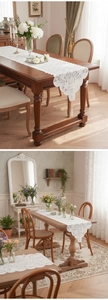 Nahaufnahme weißer Vintage-Spitzenläufer mit Blumenstickerei und eleganten Quasten